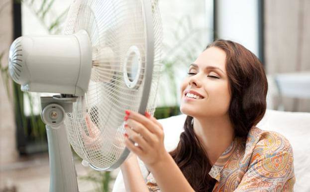 A woman using a fan to cool down, in a file image. 