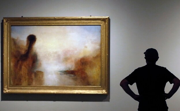 A visitor in front of one of Turner's paintings on display at the MNAC show. 