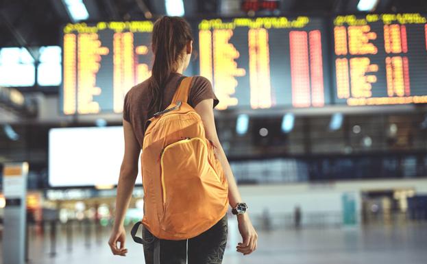 A traveler consults the list of flights. 