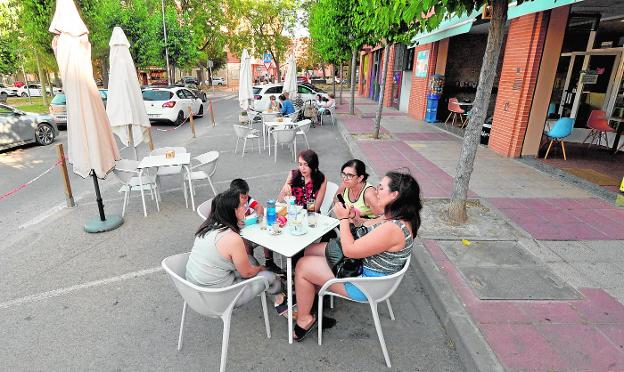 Customers on the terrace installed in a parking area in the San Basilio neighborhood. 