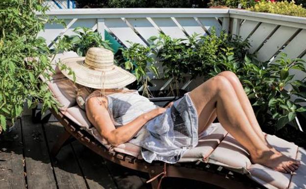 A woman sunbathes on a deckchair.