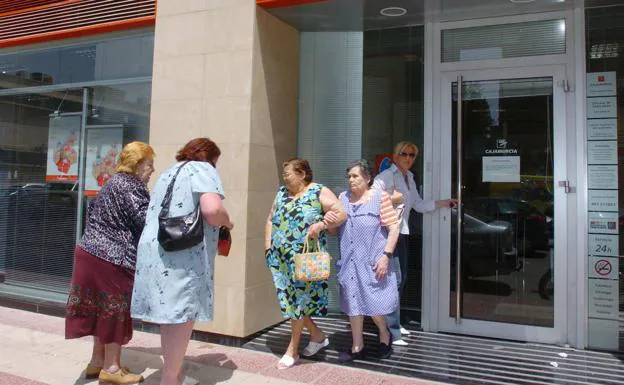 A couple of pensioner couples at the door of a bank, in a file image. 