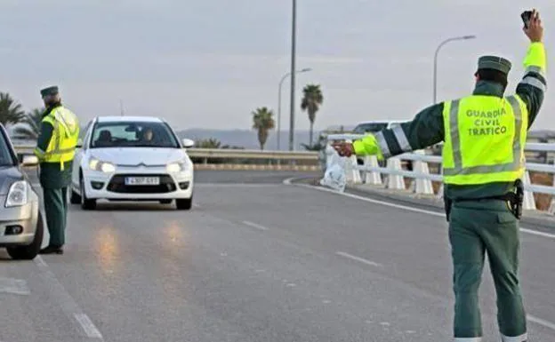 An agent stops a car at a checkpoint. 