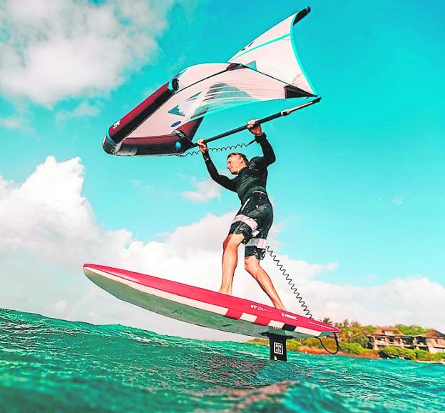 A young man practices 'wingfoil', the ultimate sensation to fly over water