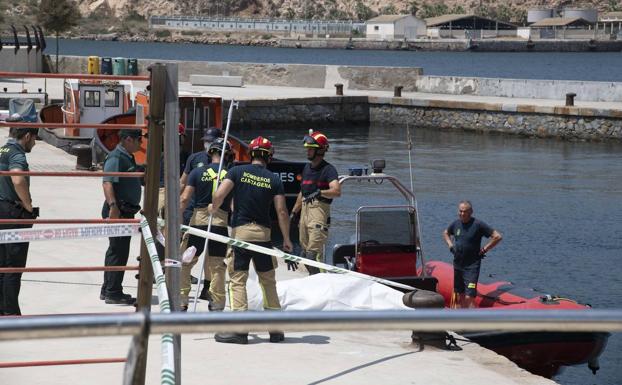 Firefighters and Civil Guard agents remove the body found this Friday in Cartagena from the water.