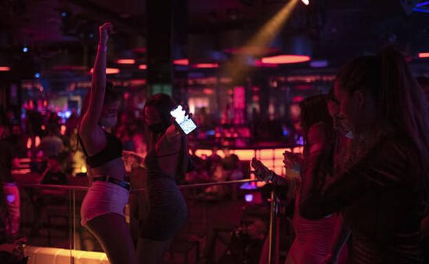 A group of young people dances in a nightlife venue in Barcelona.