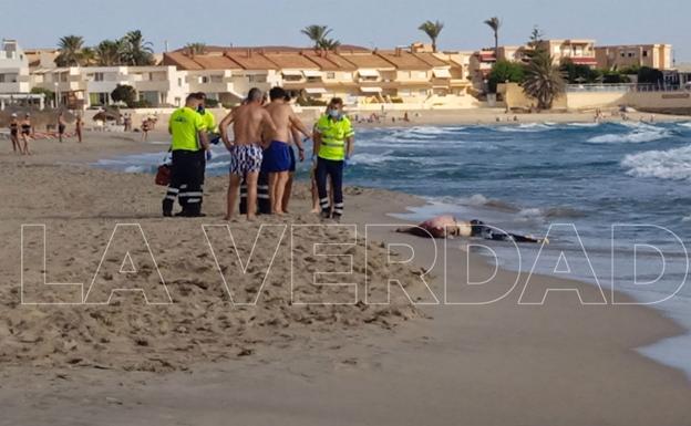 Sanitary workers and bathers, next to the body that appeared this Friday on Galúa beach. 