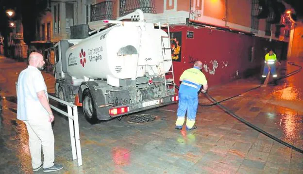 Diego Ortega supervises the cleaning work, at night, on a street in the old town. 