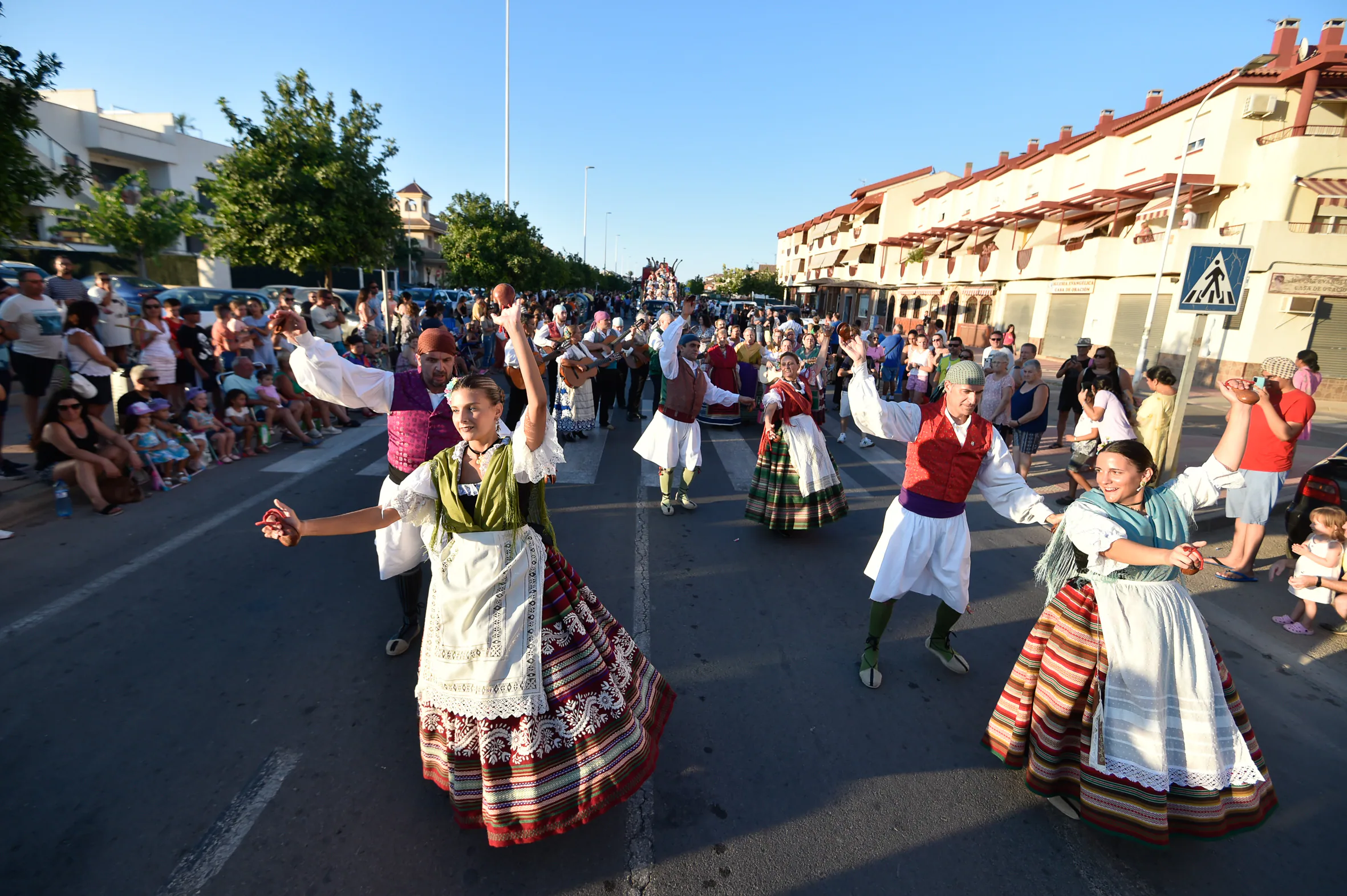 Members of an orchard rock liven up the parade with their folkloric dances.