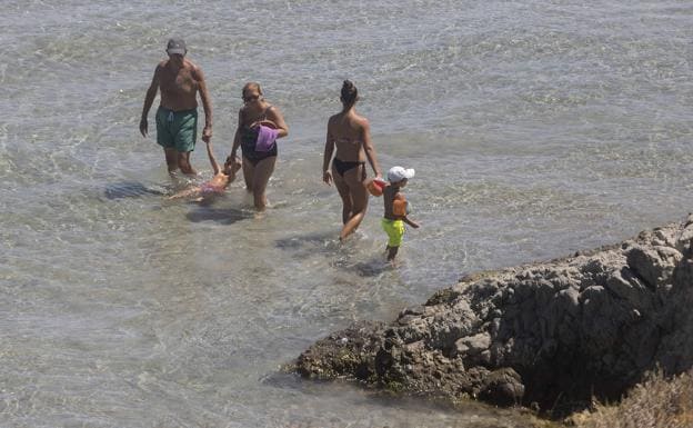 A woman and two vacationers walk by the sea with two children, yesterday, in La Manga del Mar Menor. 