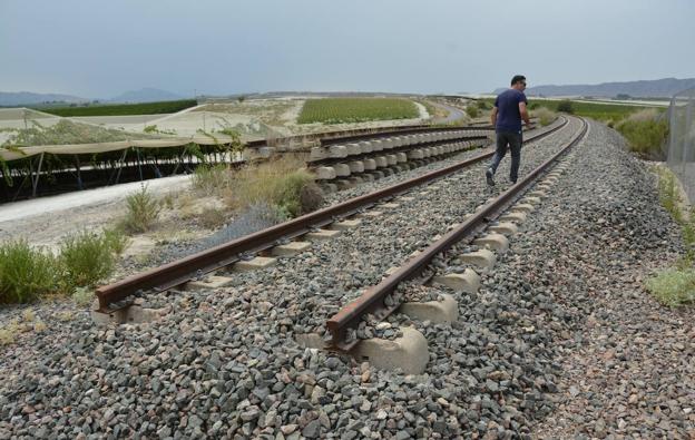A man walks along the old train track as it passes through Cieza, where the rails will be removed. 