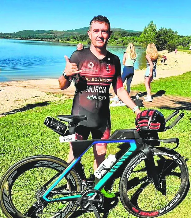 José Manuel Murcia poses with his bicycle and with the kit of the Guerrita de Alcantarilla club after a triathlon test. 