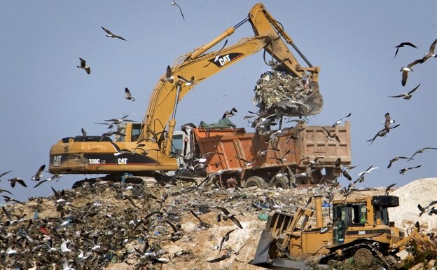 Excavator in landfill.