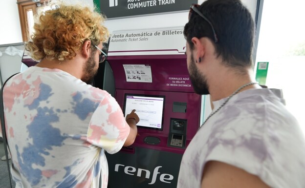 The student Fernando Vía completes the purchase process of the frequent flyer pass from one of the automatic ticket sales terminals at the Carmen station in Murcia.