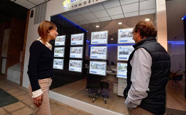Two people observe the offer of a real estate agency in Murcia, in a file photo.