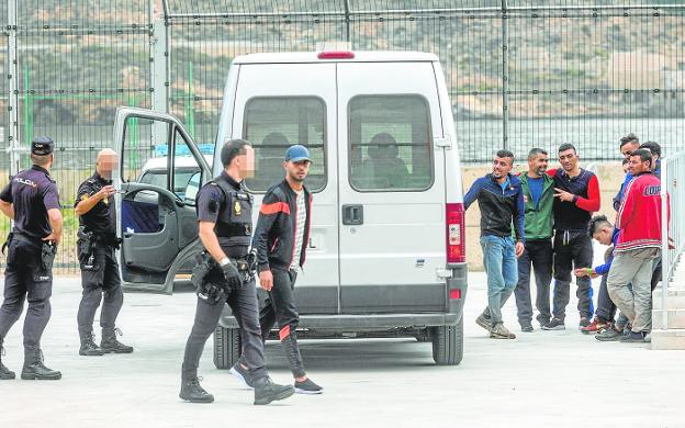 Agentes de la Policía Nacional, custodiando ayer a inmigrantes en el CATE, en El Espalmador. / PABLO SÁNCHEZ / AGM