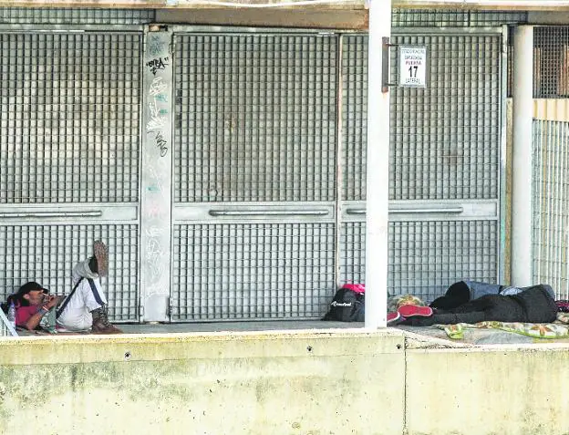 Three people sleeping yesterday in the basement of the Cartagonova Stadium, on the side that overlooks the Benipila boulevard. 